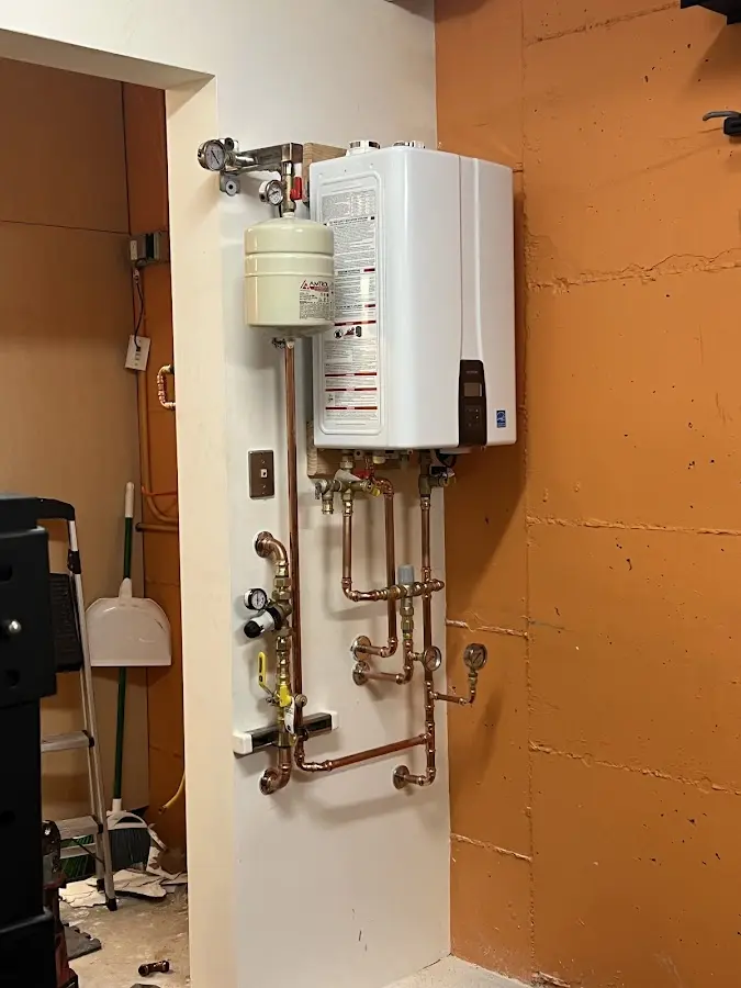 Plumbing technician inspecting water heater connections in Huntington Park